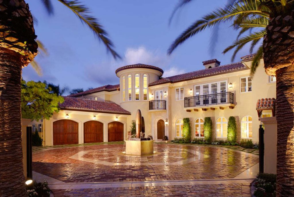 Spanish style home design with a three car garage and turret.