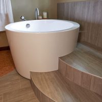 A japanese soaking tub is an anchor piece in this large primary bathroom design by Robin Rigby Fisher