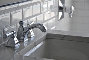 A glossy chrome faucet against white subway tile in Danielle Burger's small bathroom design.