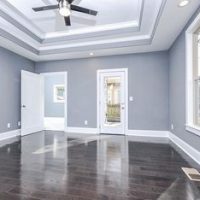 Master bedroom with grey walls, hardwood floors and a custom ceiling.