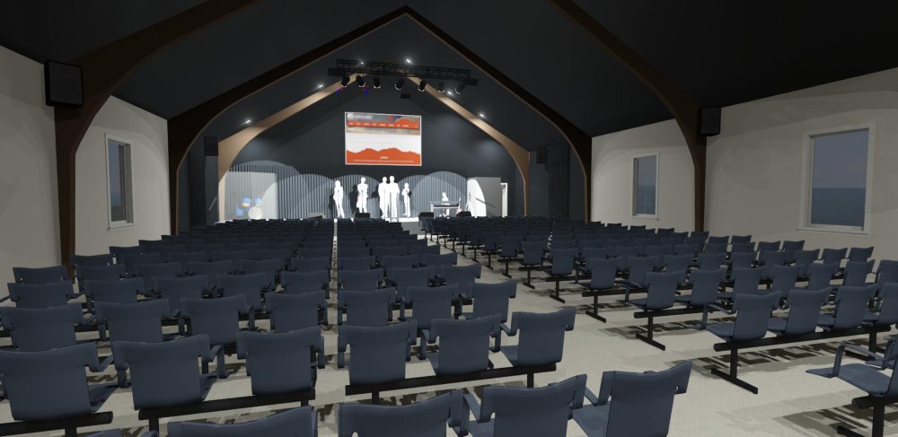 Interior of a church with vaulted ceilings, stadium seating and stage.