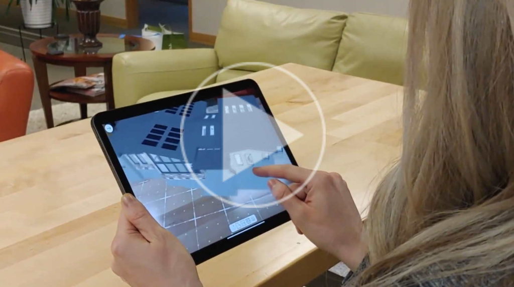 Person holding tablet using the 3D viewer app to navigate the house design in 3D.