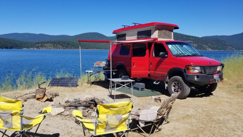 A 2001 Ford E350 extended body Sportsmobile with penthouse pop-top and a Quigley 4X4 conversion.