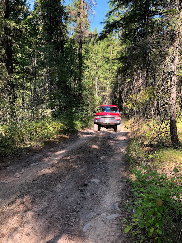 A 2001 Ford E350 extended body Sportsmobile with penthouse pop-top and a Quigley 4X4 conversion easily navigating narrow, rough terrain.