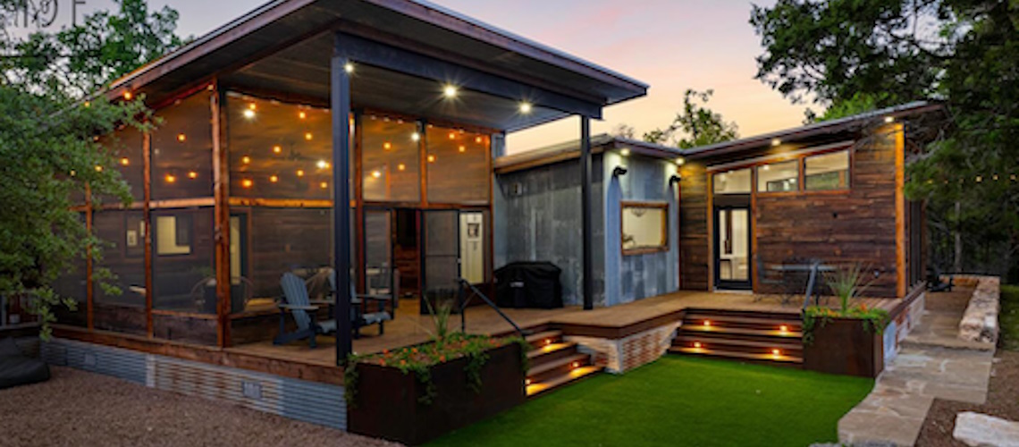 Outdoor living space with covered deck and floor to ceiling windows.