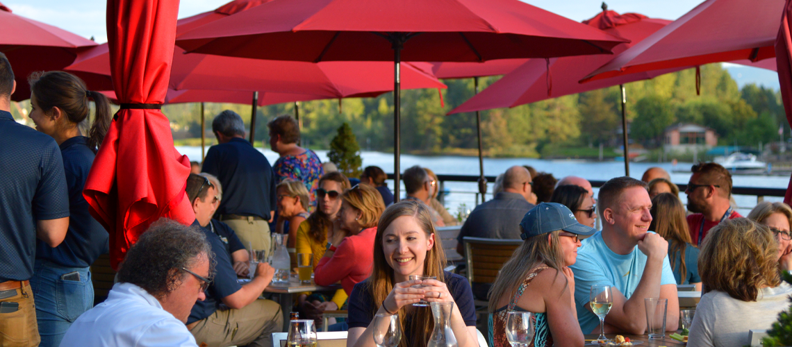 Red umbrellas over tables of happy people