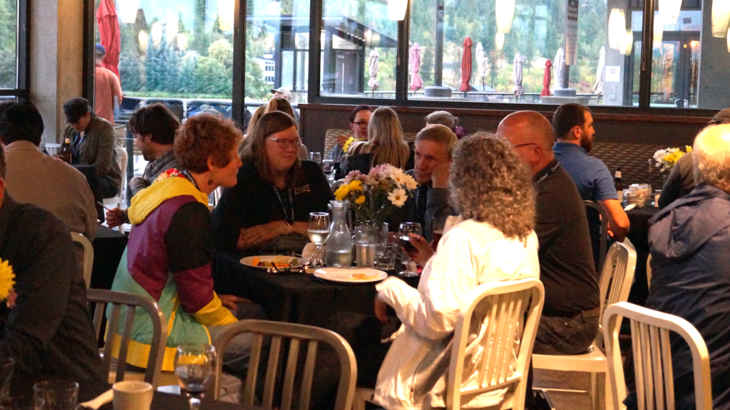 A group of Chief Architect users talking at a table with a floral arrangement in the center.