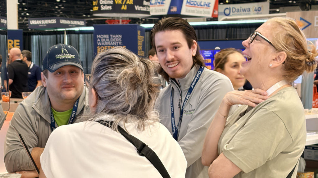 Two Chief Architect employees talking to customers and laughing. 