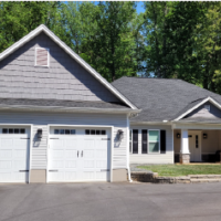 Home designed in Chief Architect with white siding, gray shakes, black shutters and a two car garage.