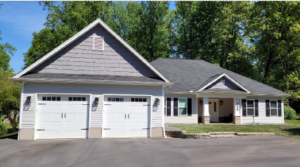 Home designed in Chief Architect with white siding, gray shakes, black shutters and a two car garage.